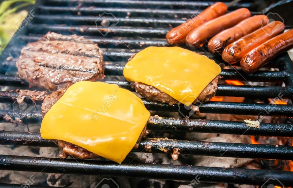 21346718-hamburgers-with-cheese-and-hot-dogs-on-grille-on-camping-trip-Stock-Photo